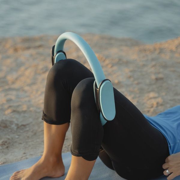 Person stretching gently on a yoga mat outdoors.